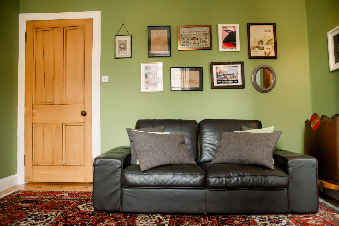 Inviting living space w/ comfy seating, colorful rug & framed artwork throughout