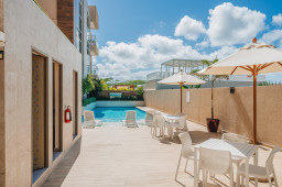 Poolside area at Aracari Residences with comfortable loungers, creating the perfect space for relaxation and leisure.