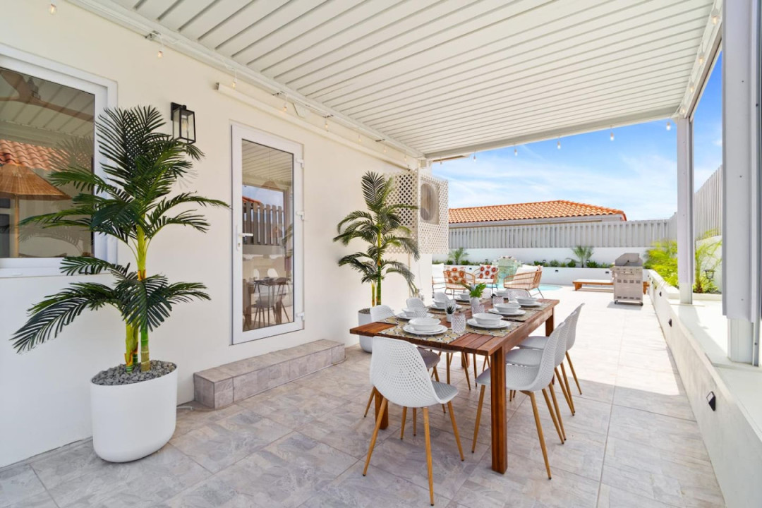 Escape to serenity in villa's shaded outdoor dining area. A tranquil retreat where the gentle breeze and comfortable furnishings create the perfect ambiance for relaxation.