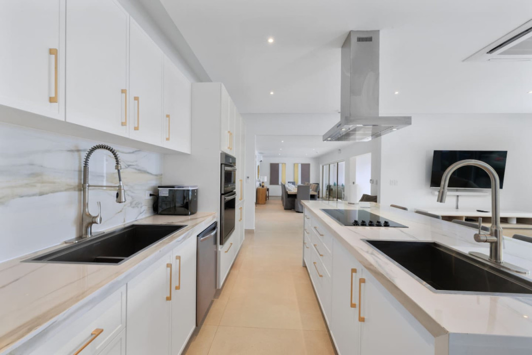 Stylish worktops, high-end appliances, and a roomy open layout make this modern kitchen the perfect place to host dinner parties and other gatherings in Villa Oasis.