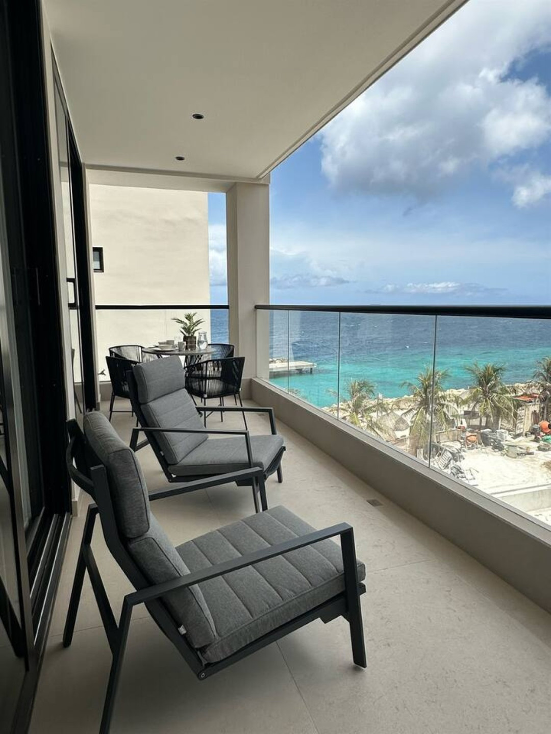 Enjoy the fresh ocean breeze and beautiful sea views from the spacious private balcony, complete with comfortable lounge seating and an outdoor dining area.
