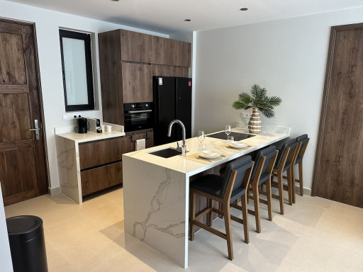 Cook, dine, and gather with ease in the fully equipped kitchen, featuring modern appliances, a large island, and comfortable counter seating for meals together.