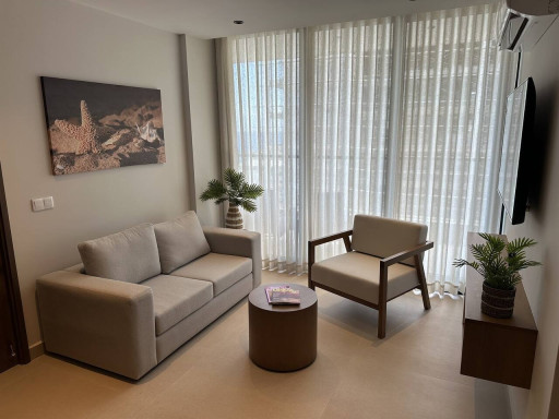 Unwind in the comfortable living room with a cozy sofa, lounge chair, coffee table, and TV—perfect for relaxing after a day out.