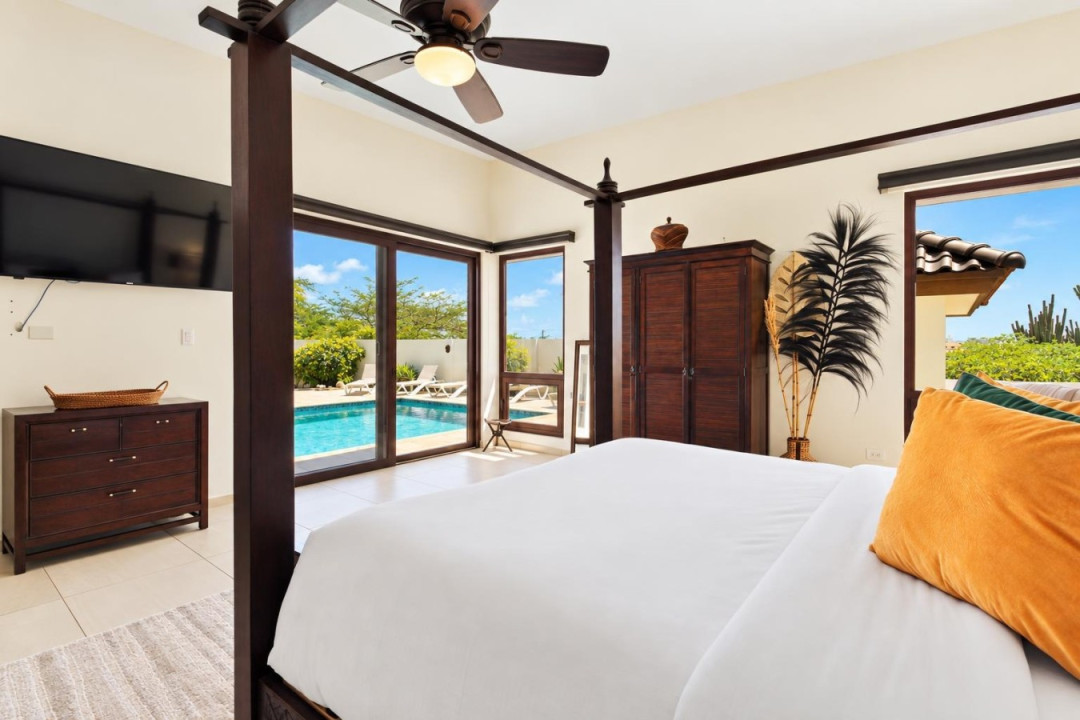 Master Bedroom 3 | The light-filled romantic master bedroom has has a king-size Balinese wood-carved four-poster bed, pool views and direct pool access. The master suite also boasts a 58’’ Ruko TV.