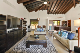 This open-concept living, and dining room feature high wooden ceilings that a photograph can never do justice.