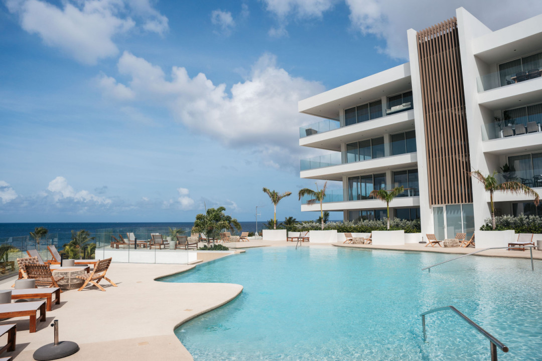 Spacious pool terrace with loungers and panoramic sea views for guests to enjoy.