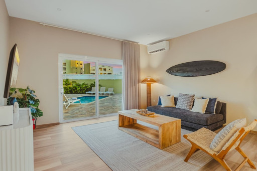 Designed for comfort and connection, this welcoming living room features cozy seating, natural light, and easy access to the private pool—making it the perfect spot to unwind after a day of island adventures.