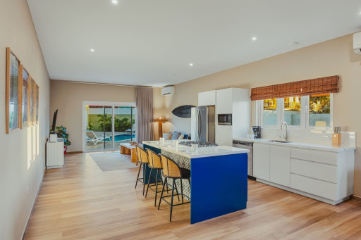 A bright, open space with a modern kitchen, cozy lounge, and direct access to your private pool—perfect for relaxing together.