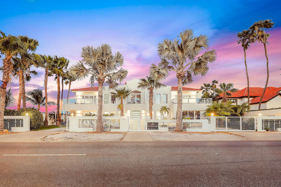 Tropical stay framed by palm trees and sunset skies.