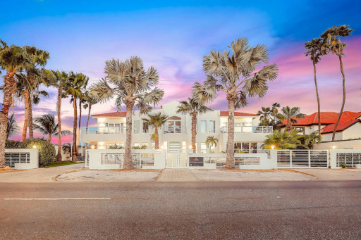 Tropical stay framed by palm trees and sunset skies.