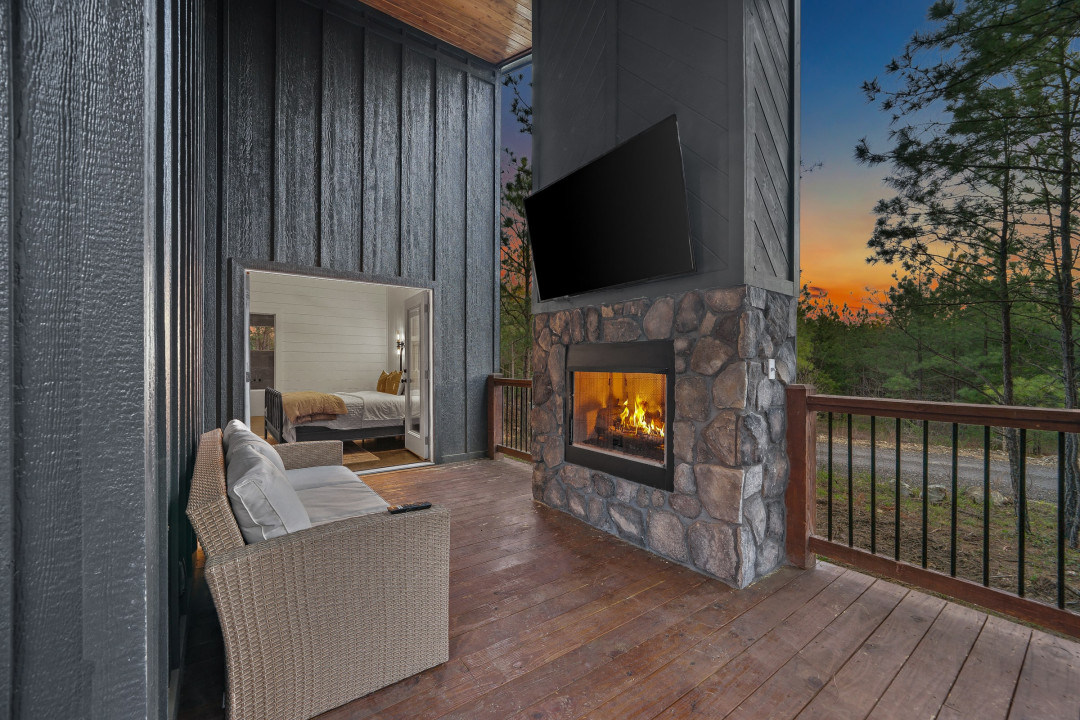 There is an outdoor lounge space with a Smart TV and fireplace.