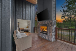 There is an outdoor lounge space with a Smart TV and fireplace.